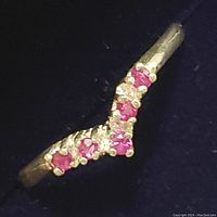 Close-up photo of the sterling silver ruby ring showing the V-shaped arrangement of five rubies against a dark background.