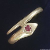 Close-up angled view of the sterling silver open-ended ring with a single round red ruby gemstone in a hexagonal setting.