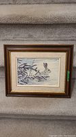 Full view of framed print showing snowy hare and surroundings.