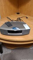Front view of silver Bose Wave Music System III with power cord and remote on top
