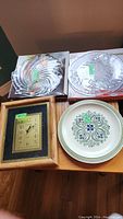 Overview photo of all four items: three serving plates and one wooden framed wall clock