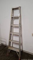 Full view of the 6-foot aluminum Featherlite ladder showing six steps and side rails with some dirt marks.