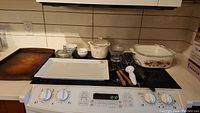 Full lot displayed on stove with baking sheet, serving platter, casserole dish, butter dish, small bowls, and kitchen utensils