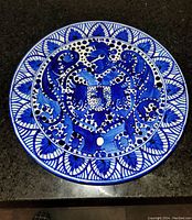 Top view of the old glazed hanging plate showing the detailed blue hand painted eagle and floral patterns on white background.