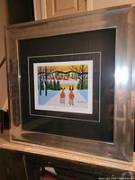 Overall view of the framed art print showing the silver metallic frame and black matting.