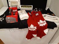 Overview of the lot laid out including socks, hats, towels, kitchen utensils, ornaments, and photo frame