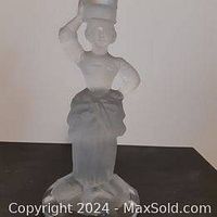 Photo of the frosted glass candle holder in the shape of a woman holding a candle above her head.