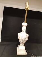 Front view of the entire carved marble lamp base with brass lamp fixture on top