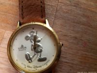 Close-up of the dial showing the Mickey Mouse figure, Lorus Quartz branding, and hands