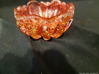 Side angle showing amber Murano glass bowl with scalloped edge and gold flecks