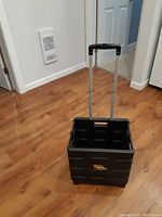 Photo of the Quik Cart unfolded with extended handle, showing interior and wheels