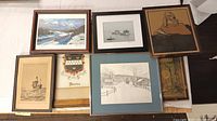 Overview photo of all framed art prints and lithos lying flat on table