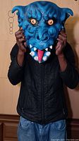 Front view of person wearing the blue demonic face mask, showing the scale and fit of the mask.