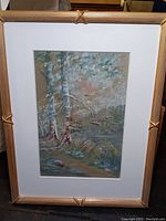 Framed watercolor print showing the full artwork of birch trees near water with white mat and light wood style frame.