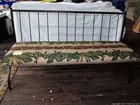 Full view of metal bench showing spindle back and safari-themed fabric seat upholstery