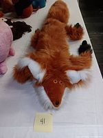 Top view of the large plush fox doll showing its face, ears, and full body facing forward.