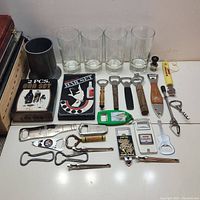Overview of metal stein, four Seagram's V.O. glasses, various promotional openers, and two bar sets in boxes.