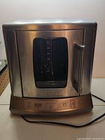 Front view of the stainless steel vertical rotisserie showing glass door and digital control panel