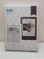 Photo of Kobo Touch eReader packaging showing images of the device in white and black with screen display of books.