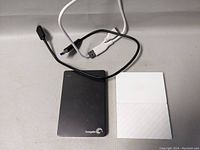 Black Seagate portable external hard drive with USB cable and white WD My Passport drive shown side by side