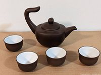Top view of the Chinese clay teapot with four tea cups surrounding it, showing the shape and size of the set