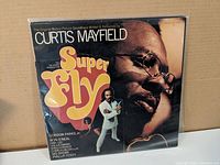 Front cover of Curtis Mayfield Super Fly soundtrack featuring Curtis Mayfield's portrait and the album title logo.