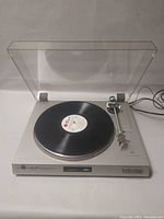 Vintage Dual CS 515 turntable with vinyl record on platter and clear dust cover raised.