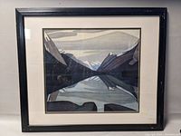 Front view of framed landscape print showing stylized mountains and water with visible reflections.