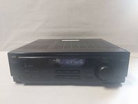Front view of JVC stereo receiver showing digital display, control buttons, volume knob, and headphone jack