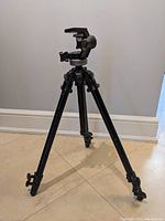 Full view of the Manfrotto 190B tripod standing extended with three legs and pan-tilt head.