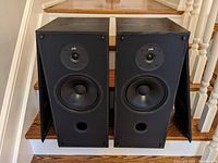 Front view of pair of PSB 500 speakers showing tweeter, woofer, port, and cabinet condition.