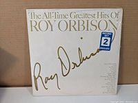 Front cover of Roy Orbison's The All-Time Greatest Hits double album showing white cover with gold text and signature, also indicating it has 2 discs.