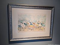 Framed serigraph print of a French village scene with tents and people under a decorative silver frame.