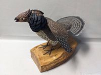 Side view of the carved wood turkey showing detailed feathers and natural wood base