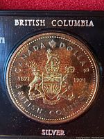 Close-up image of the coin's reverse side showing the British Columbia coat of arms, dates 1871 and 1971, and silver indication.