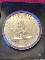 Obverse side of silver coin with image of throne and inscriptions.