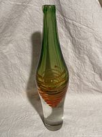 Full view of tall art glass vase showing layered colors and internal spiral design.