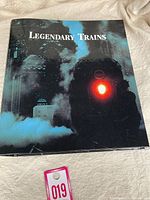 Cover of the 'Legendary Trains' user manual showing a steam locomotive with a lit red headlight surrounded by smoke.
