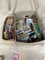 Two containers filled with assorted old hockey cards from various years.