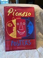 Front cover of hardcover book showing the title 'Picasso Posters' by Maria Costantino with colorful Picasso-inspired face and red background.