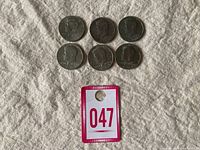 Six USA Half Dollar coins, obverse side showing John F. Kennedy profile, arranged in two rows of three coins each on fabric background. Lot tag number 047 in view.