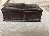 Front and side angle view showing the geometric panel design and central knob on the vintage Bakelite dresser box.