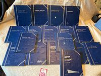 Set of 15 blue Whitman coin folders for Canadian and USA coins with empty coin slots.