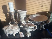 Front view of the lot showing all five ceramic pieces arranged on a black surface under natural light.