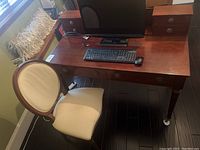 Front-left perspective showing desk top, small drawer box, keyboard setup, and chair beside desk