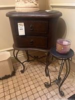 Front view of the brown kidney-shaped side table with two drawers and metal curved legs, showing the metal handles and general condition.