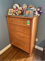 Full front view of the wood dresser with five drawers, showing the dimensions and condition of the dresser.