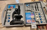 Orbitor OR 200XL microscope set in gray plastic carrying case, showing microscope and accessories including slides, vials, tools, and booklet.