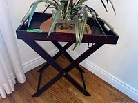 Full front view of the wood table with removable tray and plant on top
