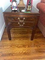 Front view of the wooden Drexel end table with two brass-handled drawers.